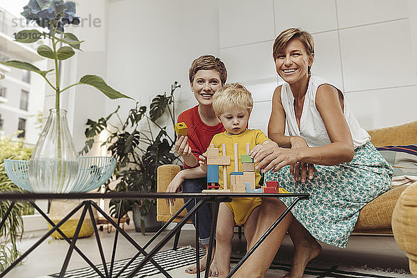 Portrait of two mothers learning and playing with their child at home