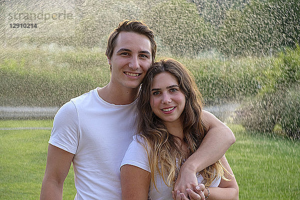 Young couple in summer standing on lawn