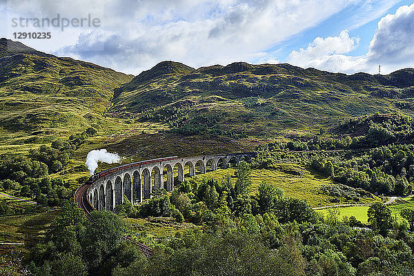 UK  Scotland  Highlands  Glenfinnan viaduct with a steam train passing over it