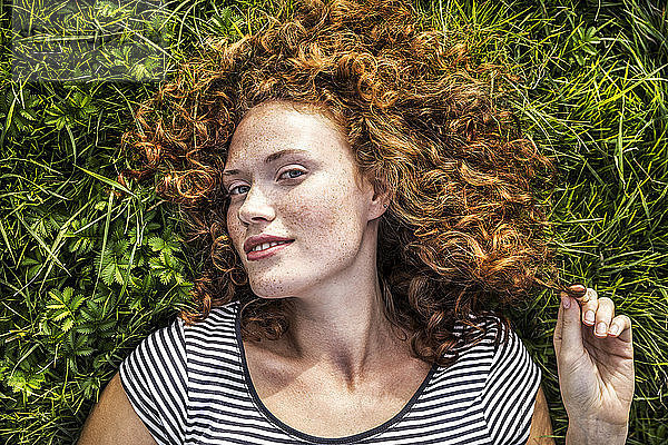 Portrait of smiling young woman lying on a meadow