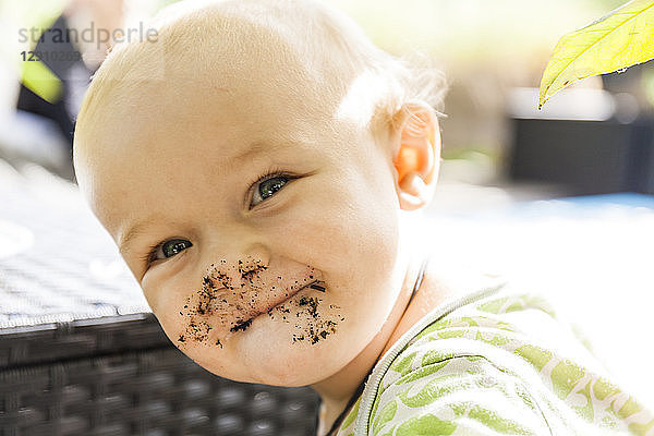 Portrait of smiling baby boy with smeared face outdoors