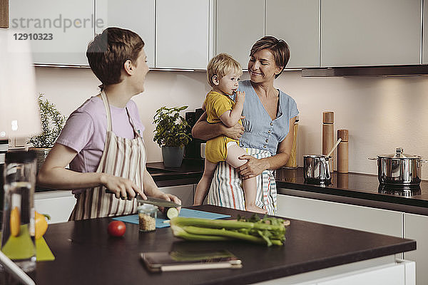 Happy lesbian couple and their child in kitchen