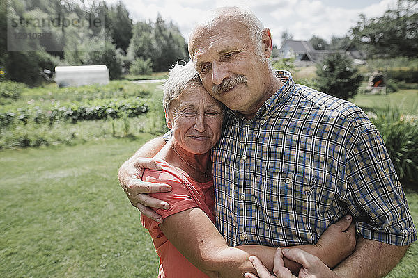 Portrait of happy senior couple embracing each other in the garden
