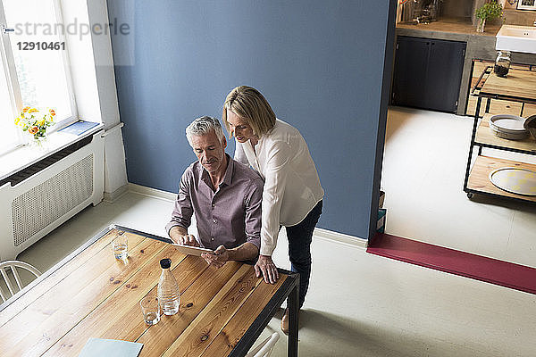 Mature couple using tablet at home