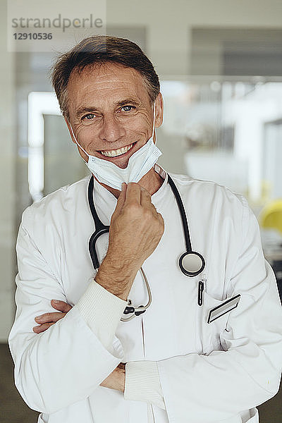 Portrait of a doctor  removing surgical mask  smiling