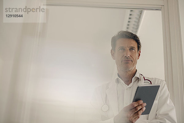 Doctor standing in hospital  using digital tablet