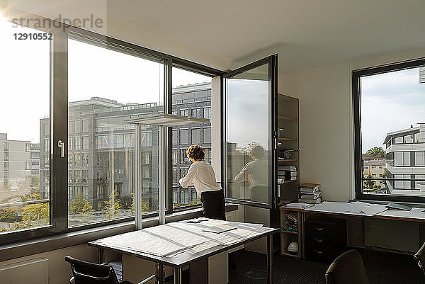Businesswoman standing in office  looking out of window