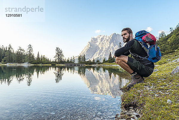 Austria  Tyrol  Hiker taking a break  crouching by the lake