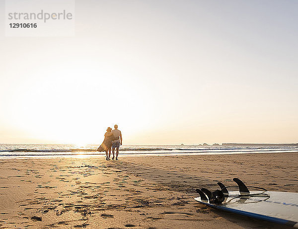 Romantic couple doing a beach stroll at sunset