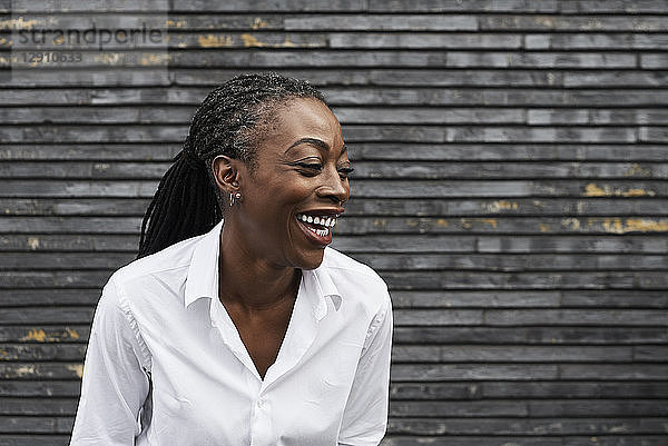 Portrait of laughing businesswoman wearing white shirt