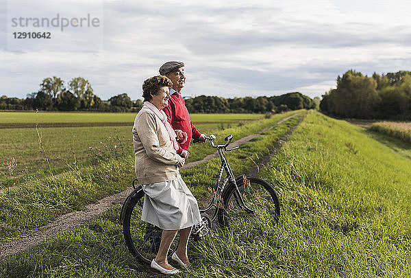 Senior couple with bicycles in rural landscape