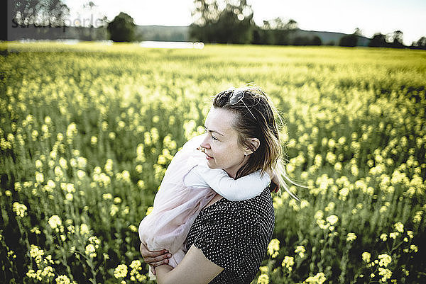Little girl on her mother's arms in rape field