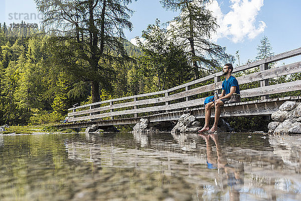 Austria  Tyrol  Hiker at Lake Seebensee sitting on boardwalk  taking a break