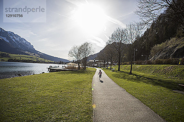 Austria  Tyrol  Walchsee  girl running on path at the lake