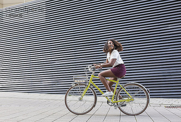Smiling young woman riding bicycle