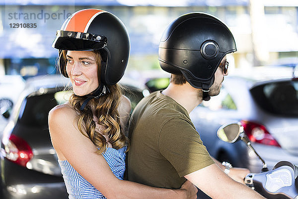 Happy couple on motor scooter in the city
