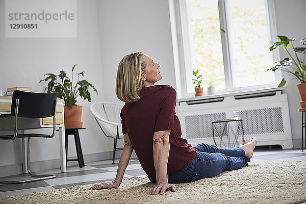 Relaxed mature woman sitting on the floor at home