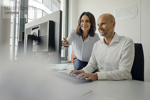 Businessman and woman working together in office