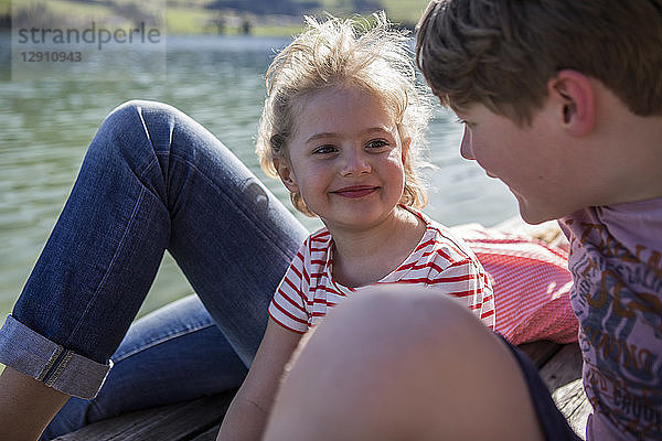 Austria  Tyrol  Walchsee  happy brother and sister smiling at each other at the lakeside