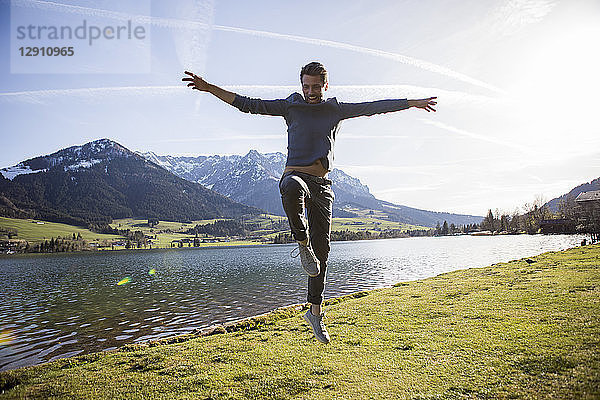 Austria  Tyrol  Walchsee  happy man jumping at the lake