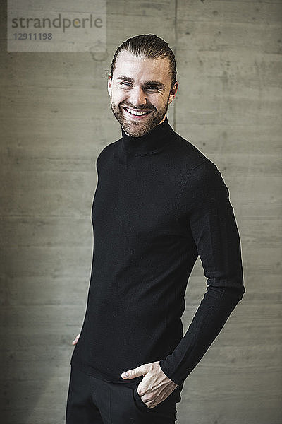 Portrait of smiling young man wearing black turtleneck jumper