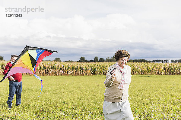 Senior couple flying kite in rural landscape