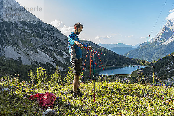 Austria  Tyrol  Hiker setting up his tent in the mountains at Lake Seebensee