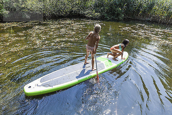 Two girls in a pond on SUP board