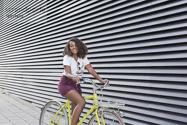 Portrait of smiling young woman riding bicycle