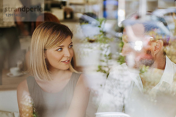 Young woman looking at man in a cafe