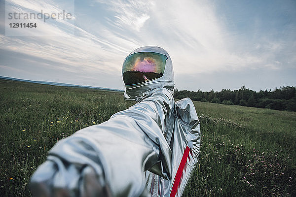 Spaceman exploring nature  reaching out hand