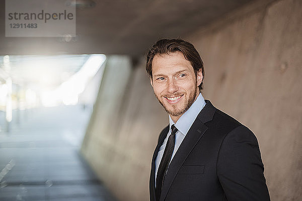 Portrait of smiling businessman in underpass