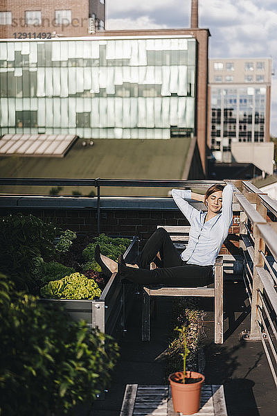 Businesswoman relaxing in his urban rooftop garden