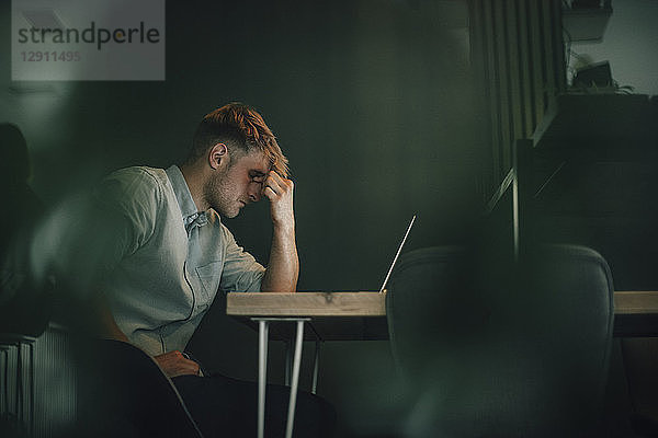 Tired man sitting in office  working late in his start-up company