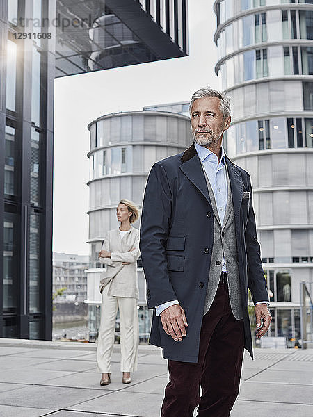Germany  Duesseldorf  portrait of fashionable mature businessman in front of modern business building