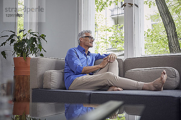 Mature man sitting on couch at home