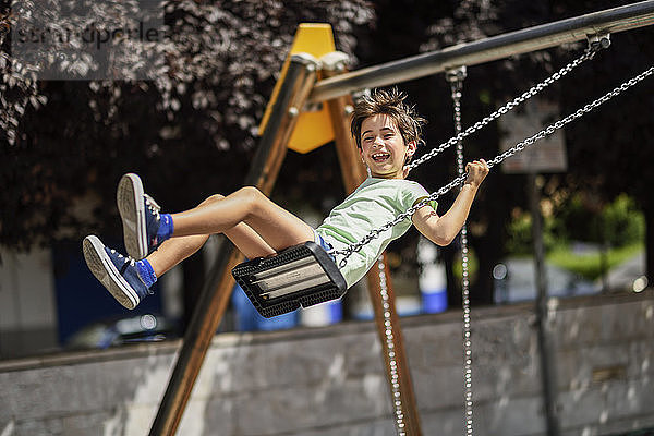 Portrait of happy little girl having fun on a swing