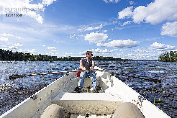 Finland  Man rowing in a boat on a lake