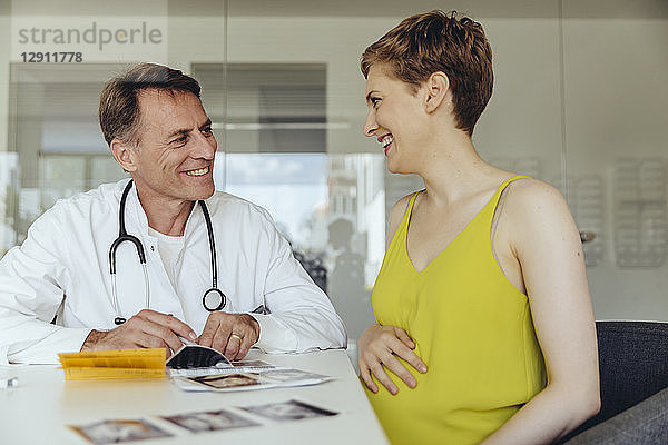 Pregnant woman discussing ultrasonic scans with her doctor