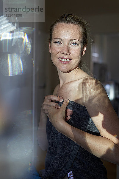 Portrait of a smiling woman  wrapped in towel