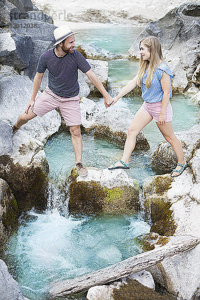 Young couple crossing river