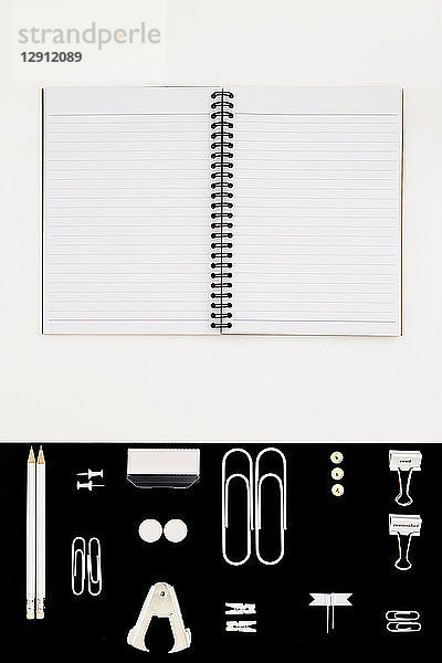 White office utensils on black background and notepad on whilte background