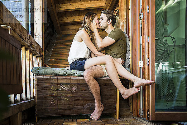 Affectionate couple kissing on balcony