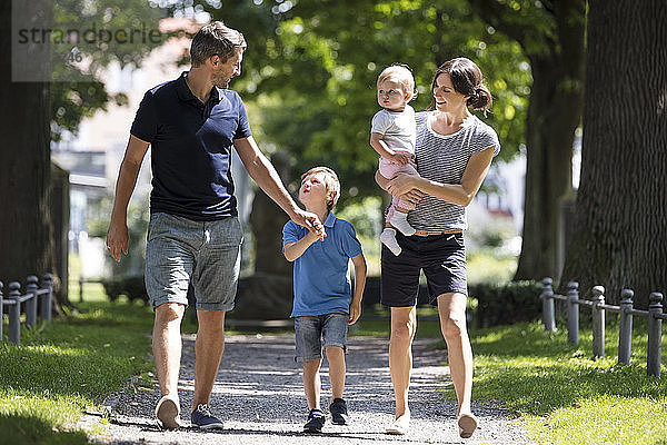 Happy family with two children walking in park