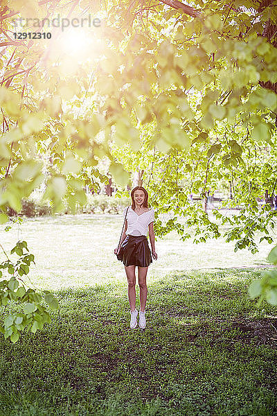 Smiling young woman standing in a park