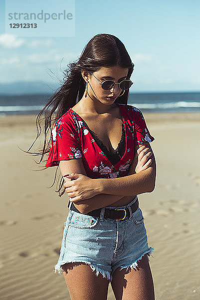 Portrait of fashionable teenage girl standing on the beach