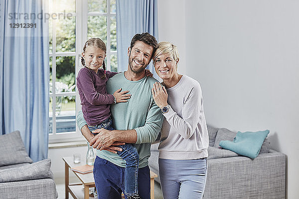 Portrait of happy parents with daughter at home