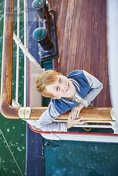 Boy with red hair standing at reeling  looking up to camera