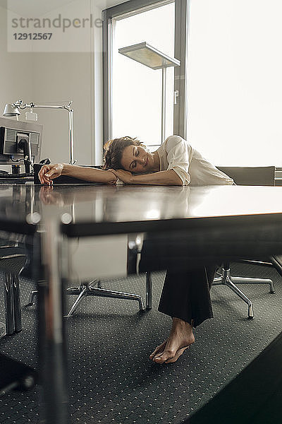 Tired businesswoman sleeping on her desk