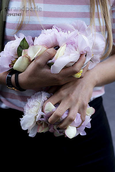 Hands of young woman  holding peonies
